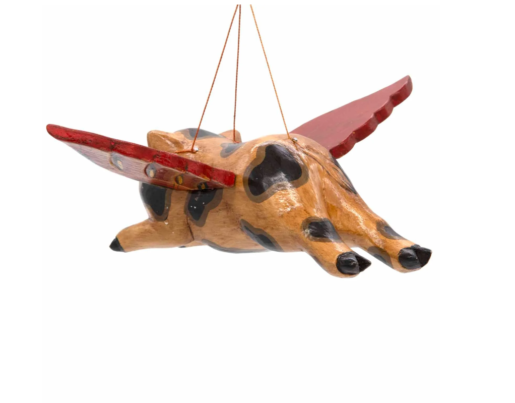 Wooden birdhouse shaped like a flying dog with red wings on a white background