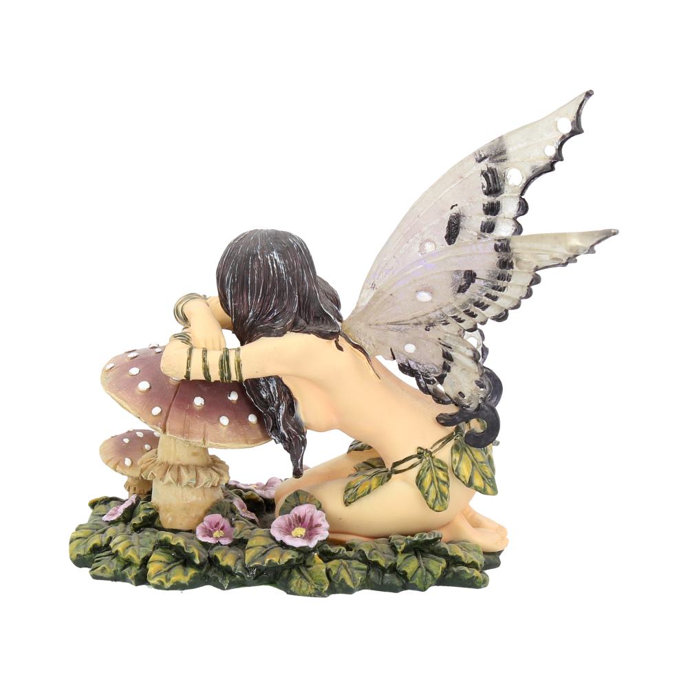 Fairy figurine with butterfly wings sitting on a mushroom with flowers around, on a white background