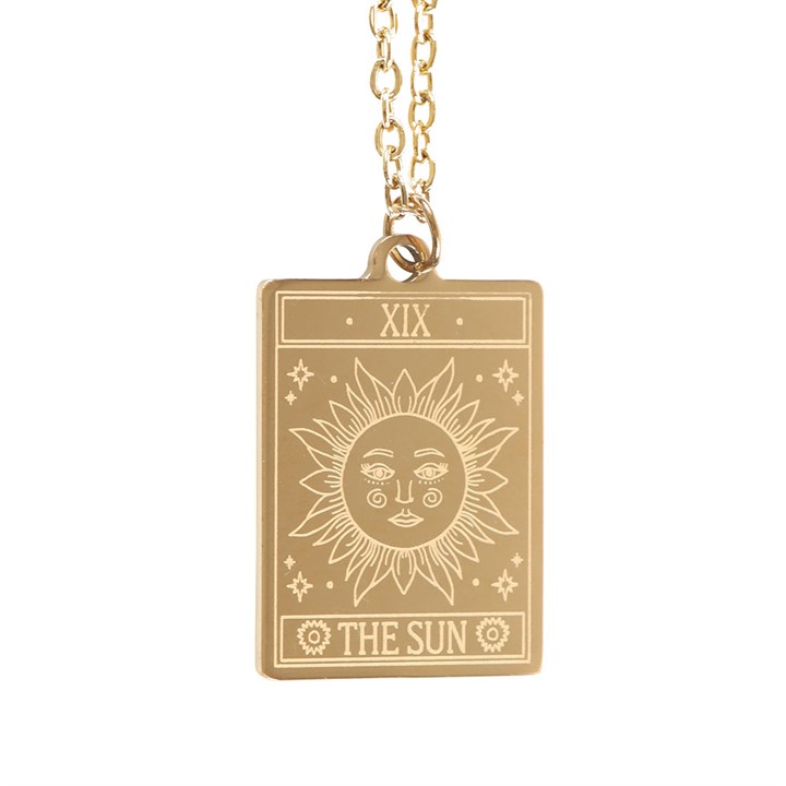 Gold necklace with a sun design pendant on a white background