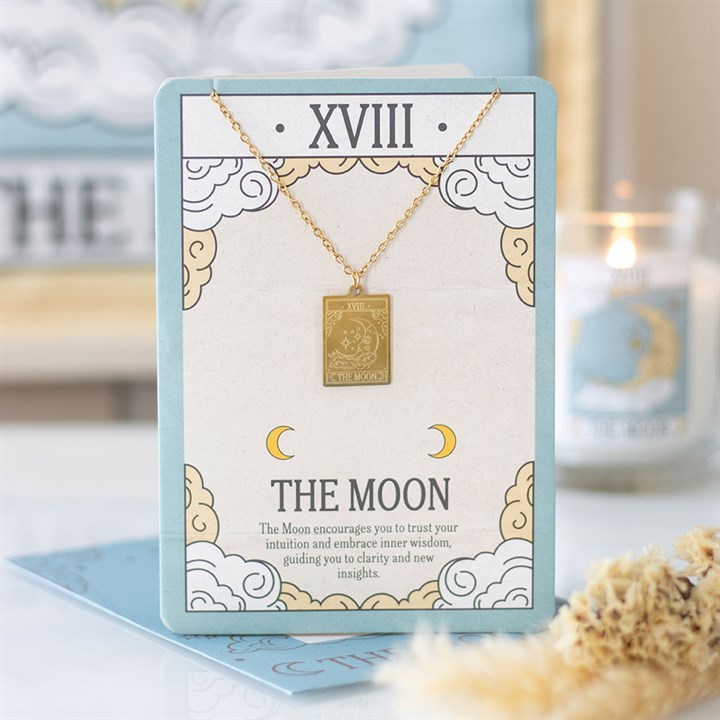 Gold necklace with a pendant on a card labeled 'The Moon' with decorative elements.