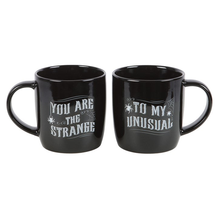 Celebrate a love that’s anything but ordinary with the You Are the Strange / To My Unusual Mug Set — a perfectly mismatched pair for couples who share a dark sense of humour and an even deeper connection.

Each 350ml black ceramic mug features gothic-style lettering that reads “You Are the Strange” and “To My Unusual”, paying tribute to the wonderfully weird bond between soulmates who thrive on the strange and extraordinary.

Crafted for daily rituals, this microwave and dishwasher safe mug set blends pract