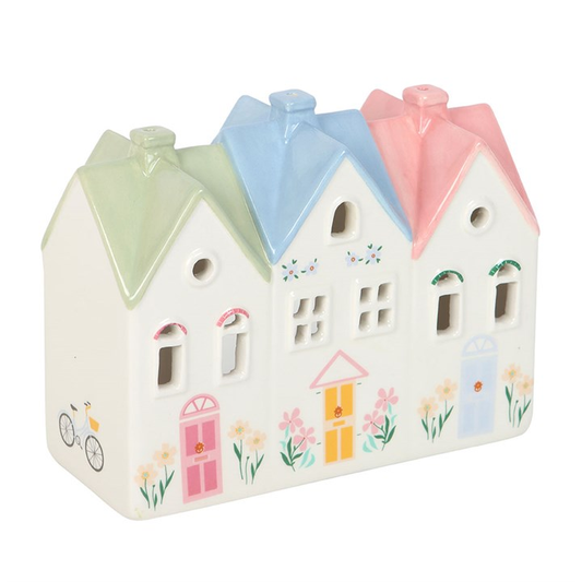 Decorative ceramic house with pastel-colored roofs on a white background