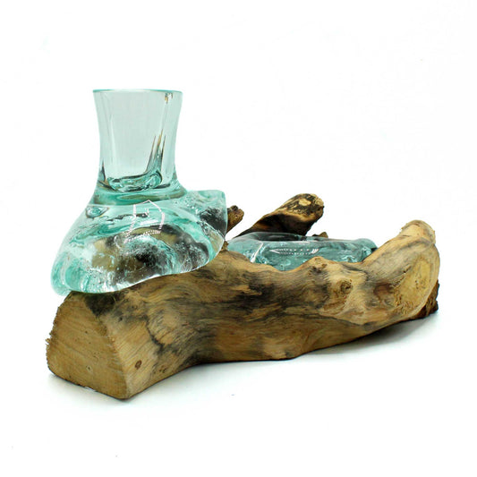 Discover the harmony of fire and earth with our Molten Glass Small Flower Vase & Tealight Holder on Wood. Handcrafted in Bali, this unique piece features a transparent molten glass vase paired with a tealight holder, both resting naturally on a base of sustainably sourced Gamal wood. Each base is shaped by nature’s hand, with flowing grain patterns that make every creation truly one-of-a-kind.

In folklore, molten glass embodies renewal and transformation, while wood symbolizes grounding and strength. Toget