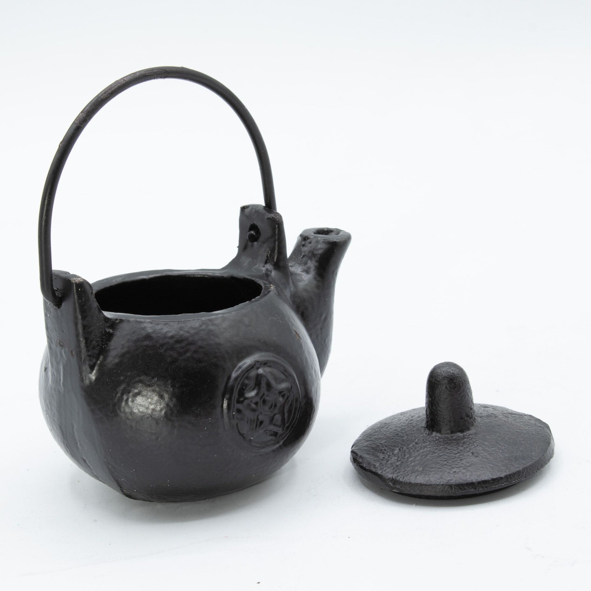 A darkly elegant ritual pot forged from solid cast iron, crowned with a protective lid and commanding side handle. The pentagram embossed upon its surface marks it as a vessel for serious craft—perfect for burning sacred herbs, charcoal, or incense during your most potent workings. Compact yet commanding, this 8x8x10cm cauldron sits perfectly on altar or shelf, radiating gothic presence. The cast iron construction holds heat steadily, containing ash and smoke between rituals while its fitted lid keeps your 