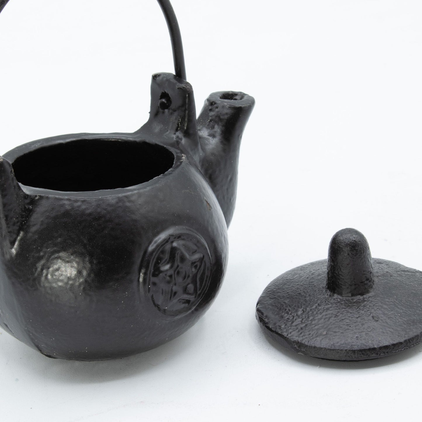 A darkly elegant ritual pot forged from solid cast iron, crowned with a protective lid and commanding side handle. The pentagram embossed upon its surface marks it as a vessel for serious craft—perfect for burning sacred herbs, charcoal, or incense during your most potent workings. Compact yet commanding, this 8x8x10cm cauldron sits perfectly on altar or shelf, radiating gothic presence. The cast iron construction holds heat steadily, containing ash and smoke between rituals while its fitted lid keeps your 