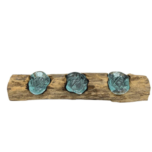 Invite a warm, soulful glow into your home with our Molten Glass Flat Triple Candle Holder on Wood. Handcrafted from recycled glass and natural Gamal wood, each piece is a one-of-a-kind work of art. The molten glass is shaped and fused to the wood, creating three natural bowls that rest perfectly in balance—an earthy yet elegant way to display candles.

In bohemian folklore, glass formed by fire represents renewal and transformation, while wood grounds us in nature’s energy. Together, they create a candle h