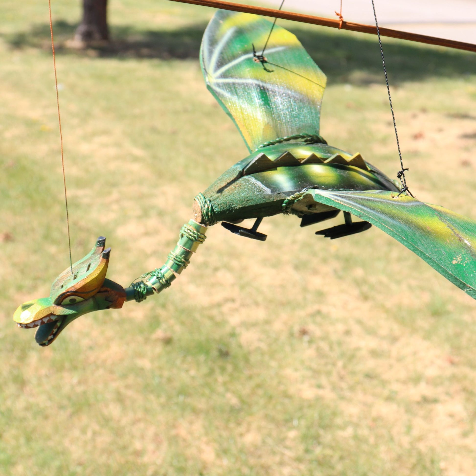 Green coconut dragon hanging mobile with 37cm wingspan. Unique garden or home dragon decor that moves gently in the breeze.