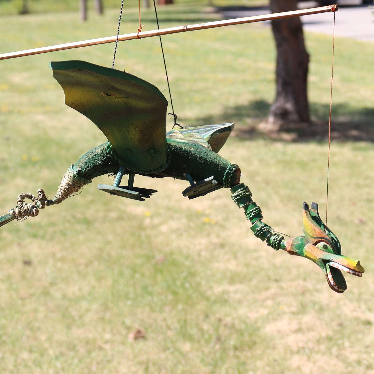 Green coconut dragon hanging mobile with 37cm wingspan. Unique garden or home dragon decor that moves gently in the breeze.