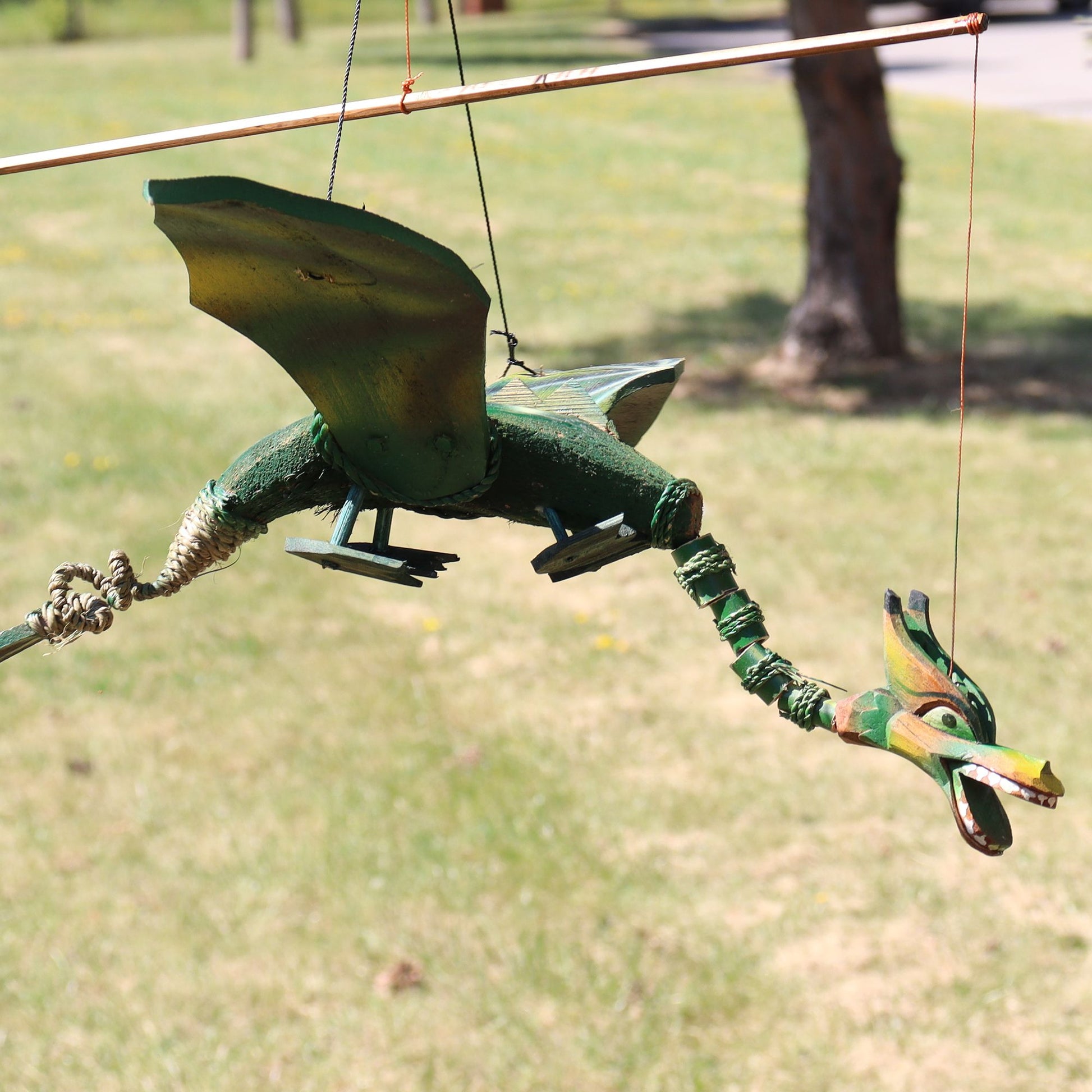 Green coconut dragon hanging mobile with 37cm wingspan. Unique garden or home dragon decor that moves gently in the breeze.