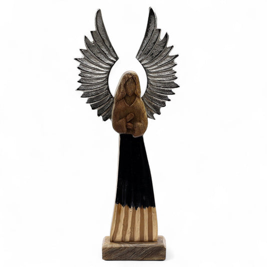 From the divine artisans of thewitchesgarden, this Large Mango Wood Guardian Angel stands as a celestial sentinel of strength, protection, and grace. Rising 40cm tall, each angel is hand-carved from sustainable mango wood and adorned with silver-toned metal wings that shimmer like moonlight. The flowing robe, finished in deep black enamel, adds a touch of mystery and timeless elegance.

Every piece is crafted in India with a balance of natural wood grain, cool metal, and lustrous enamel — an artful blend of