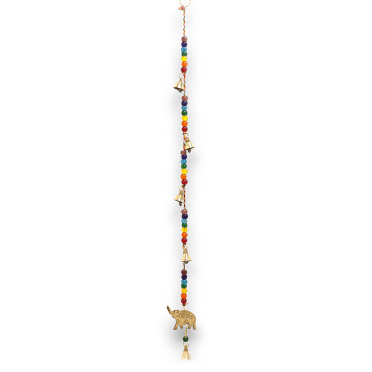 Welcome balance, protection, and uplifting spiritual energy into your space with these Indian Chimes featuring a finely crafted brass elephant and vibrant chakra beads. The elephant, long regarded as a symbol of strength, wisdom, and good fortune, forms the centrepiece of this hanging, while the chakra-coloured beads add a radiant touch aligned with energetic harmony.

Suspended below, delicately tuned string bells create a soft, soothing sound that calms the atmosphere and enhances meditation, relaxation, 