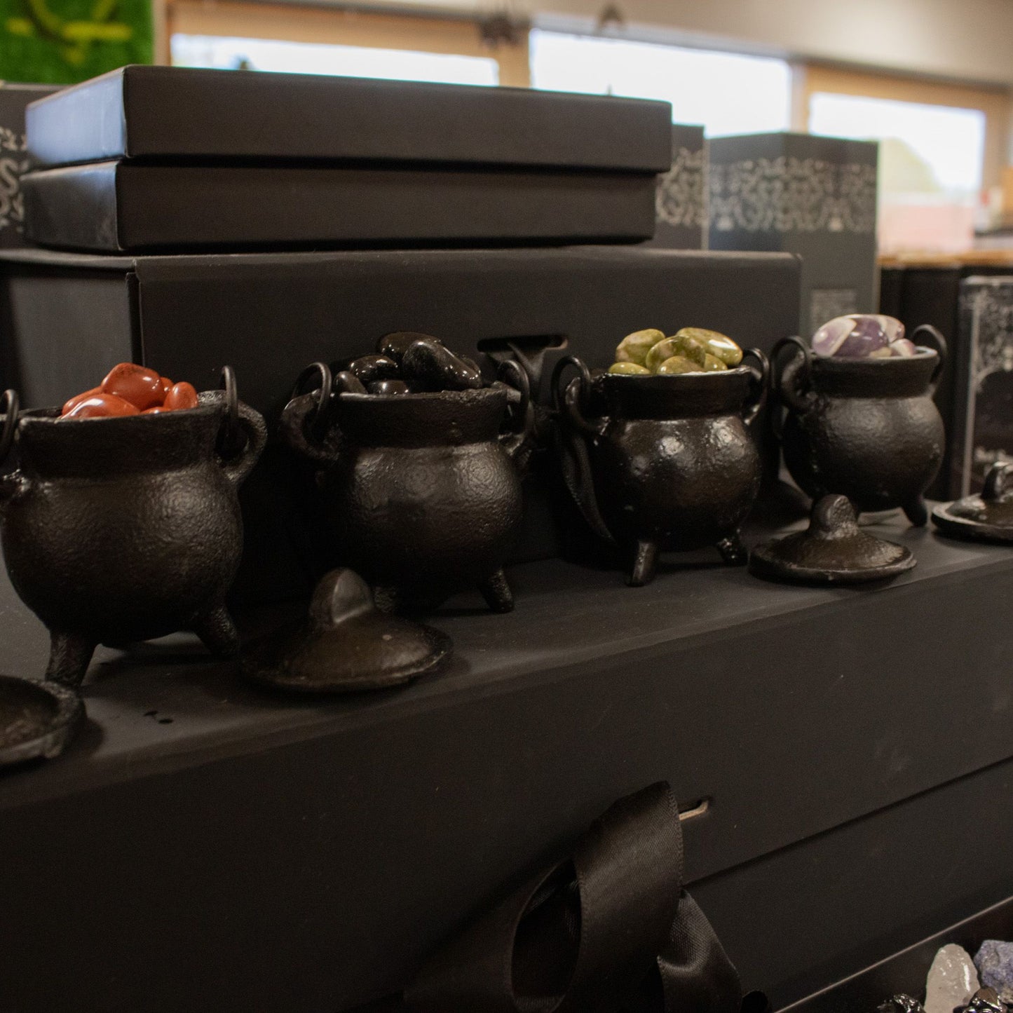 Small, simple, and brimming with gothic charm. This set of four extra small cast iron cauldrons captures the essence of witchy tradition in a perfectly petite size. Perfect for burning incense, herbs, or cones, they nestle beautifully on shelves, altars, or desks without demanding space. The sturdy three-leg base keeps them grounded and stable, while the fitted lid traps ash and contains the mystique. Each cauldron features a small handle for effortless repositioning between your sacred spaces. A versatile,