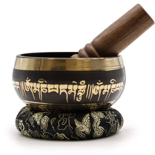 Tibetan singing bowl with wooden striker on a white background