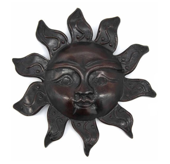 Decorative sun wall art with a face in the center on a white background