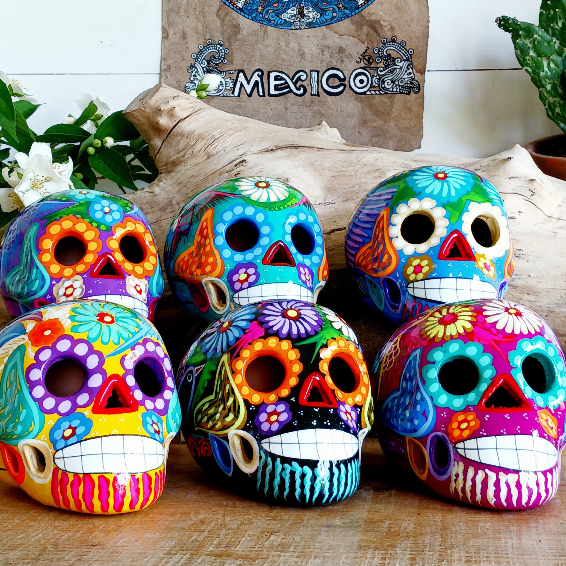 Colorful sugar skull decorations on a wooden surface with 'Mexico' text in the background.