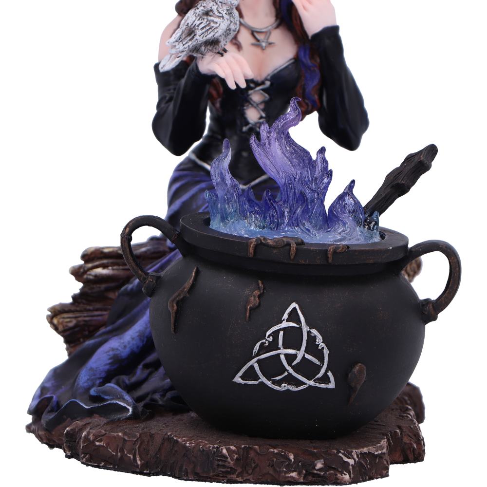 Decorative figurine of a witch in a cauldron with a dark background