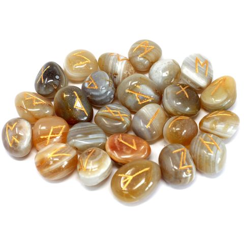 Unlock the wisdom of runic divination with this exquisite Banded Agate Rune Set. Each set includes 25 smooth, hand-carved stones: 24 engraved with sacred runic symbols and 1 blank stone, all beautifully housed in a soft pouch for safekeeping and ritual use.

Banded Agate is known for its grounding and stabilizing energy. It helps balance emotional, physical, and intellectual energy, and is believed to harmonize yin and yang—the positive and negative forces of the universe. Ideal for meditation, spiritual gu