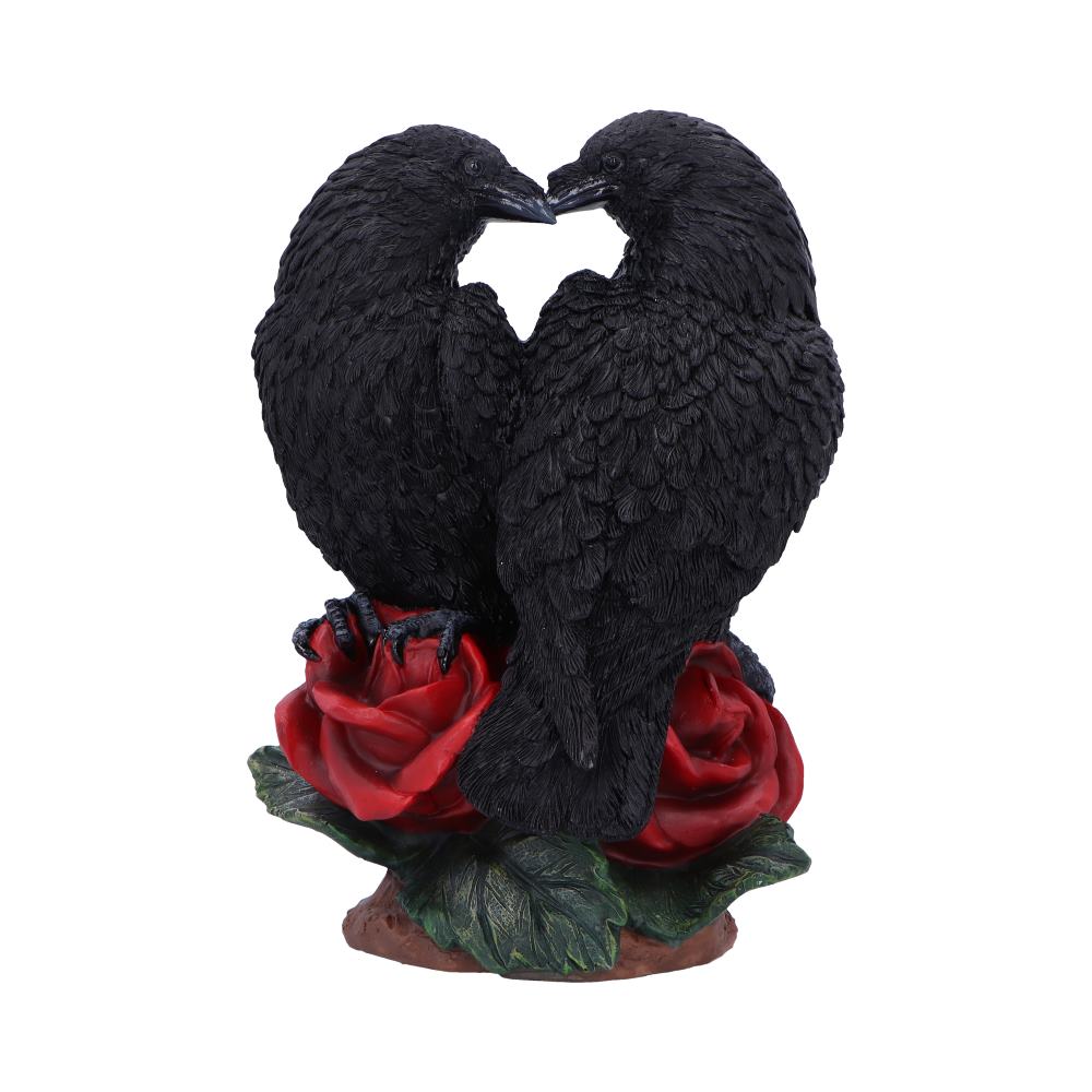 Statue of two black birds forming a heart shape over red roses on a white background
