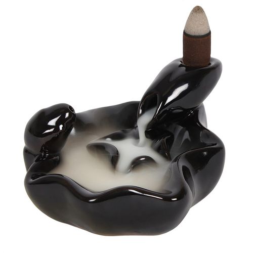 A stunningly simple black ceramic backflow incense burner in a pool to pool design.When the cone is lit the smoke from the cone pours downwards into the small pool then cascades in to the larger pool in a mesmerising waterfall effect. Beautiful to watch. For best effects burn indoors in an area away from any sudden air movements. Please note that after burning it is normal for a light oily residue to appear on the oil burner, for this reason we recommend protecting any furniture it is placed upon suitably. 