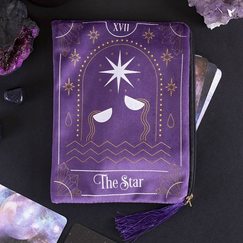 Purple tarot card holder with 'The Star' design on a dark surface with tarot cards and crystals.